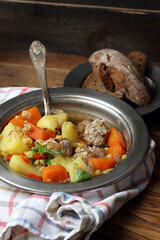 Homemade rustic soup with meatballs, peas, carrots, potatoes, onions, garlic, chili and parsley