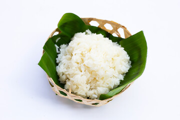 Sticky rice on banana leaf in bamboo basket on white background.