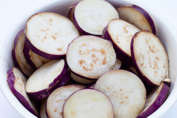 Fresh eggplant in white bowl