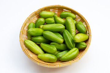 Bilimbi fruit in bamboo basket on white background.