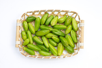 Bilimbi fruit in bamboo basket on white background.