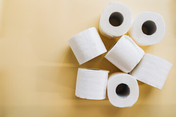 rolls of white toilet paper on a beige background with space for text. toilet paper top view copy space