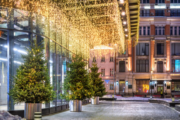 Christmas trees near the entrance to the Central Department Store in Moscow in the light of night lights