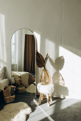 full-length mirror in the interior of a bright room in the style of a New York loft. details of a room with white walls and a large mirror. boho style room.