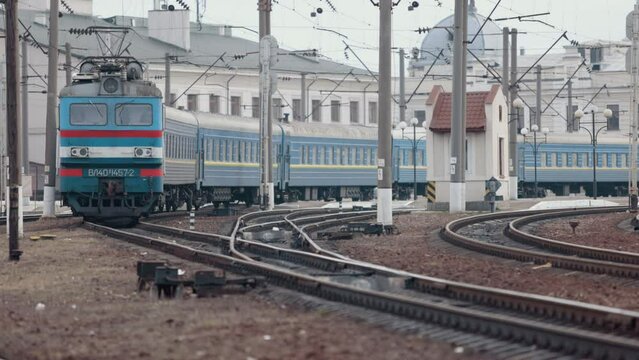 Old electric train moving by rail. Outdated design. Soviet electric train traveling. Transportation concept. Old diesel vehicle travels along the railway line. Suburban passenger transportation.