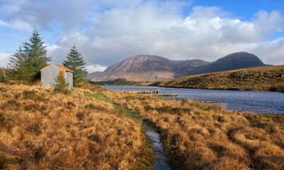 Small house in wilderness surrounded with river and mountains at Derryclare natural reserve in Connemara National park, county Galway, Ireland 