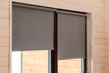 Fabric blinds on the window. Roller Blinds on Window on Wooden Wall. Modern sunproof blinds grey pastel color 