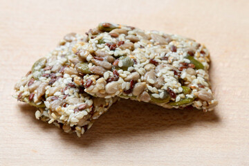 A muesli bar with seeds on a wooden table.