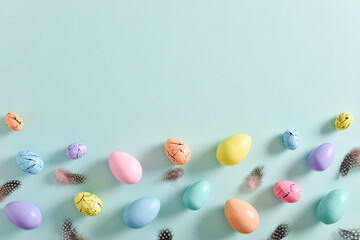 Easter card with bed-colored eggs and feathers