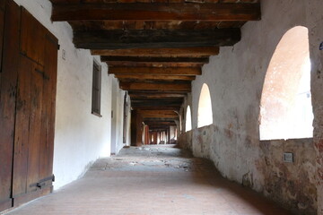 The ancient elevated covered “donkey road” in Brisighella built inside the buildings has ceiling with wooden beams and arched windows 