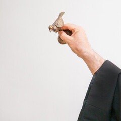An Armenian priest holds a bird figurine in his hand and performs the rite of baptism over the font