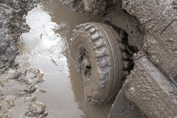 Car wheel stuck in mud, motorsport, mud tire testing. Off-road driving, car breakdown. Emergency...