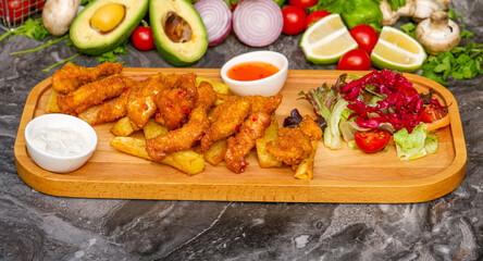 Crispy coated deep fried chicken pieces with french fries and salad