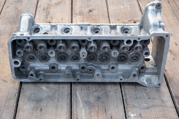 car cylinder head. car engine body. wooden background. car engine after repair. top view.