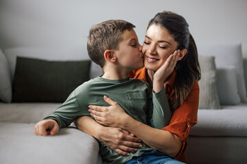 Kind single mother, giving her son attention, while he touches her cheek and kisses her.