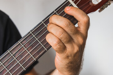 A male hand playing D7 chord in spanish guitar