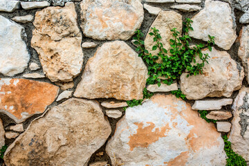 Stone antique old wall as a background or texture. Vintage background of a fortress wall in loft and grunge style with place for text and copy space.