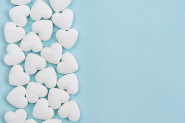 Border of white shaped pills on a blue background. Cardiovascular disease treatment concept. Top view, flat lay, copy space.