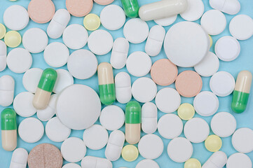 Close-up of pills on a blue background. Medicine, treatment and recovery.