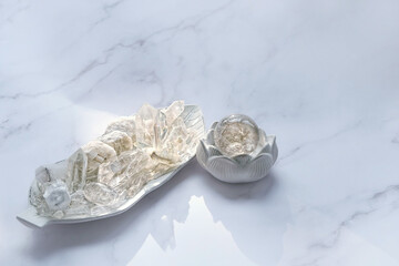 Set of clear quartz minerals and crystal ball on marble background. gemstones for esoteric...
