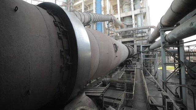 Big tube working in the big factory. Pipe is turning. Pipe transporting raw materials. Tube transporting liquid.