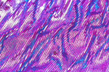 Fabric with sequins as a background. Glittery texture is the trend of the season. Sparkling color holographic blue, pink.