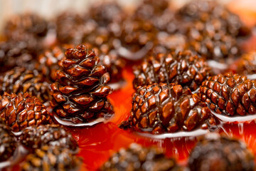 Young pine cones jam. Useful and tasty dessert. Traditional Siberian dessert - young pine cones jam. Glass ramekin of jam made from pine cones on a white background.