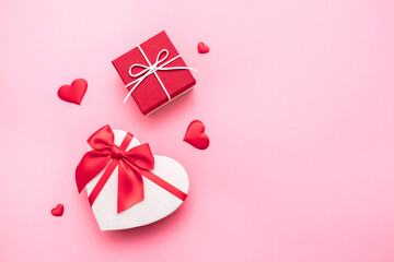 Valentine's Day. Gifts in the form of hearts on a pink background with the inscription love. Copy space for text. The concept of romance and love.