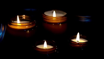 Aroma candles in brown glass jars. The candle burns in the dark. Aromatherapy, romance and relaxation in the spa. Scented and soy candles burn at night. Wax and paraffin in a jar.
