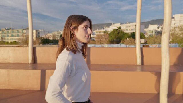 Truck shot of a young woman walking during golden hour. UHD quality