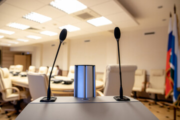 Microphone in seminar room, conference event or press conference Abstract blurred background. News conference. Political debate during answering media questions.