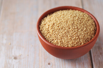 Dry couscous in a small ceramic bowl