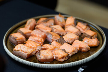 Fried salmon small pieces. slices, cubes. closeup on a ceramic plate