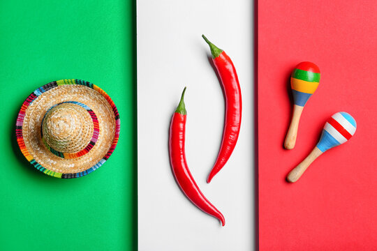 Mexican sombrero, maracas and hot chili peppers on  Mexican flag background