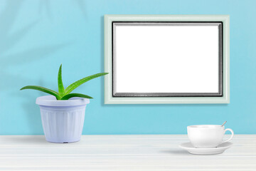 Poster template. Photo frame on wooden table with homemade flower and cup of coffee