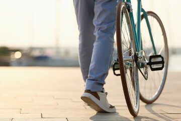 Young man with bicycle on embankment, closeup