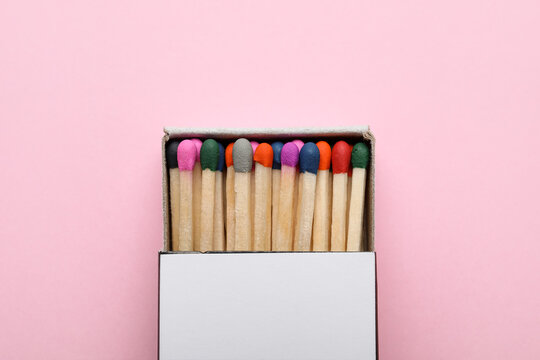 Box with new matchsticks on pink background