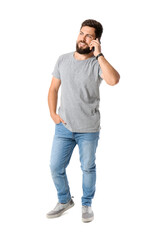 Handsome man in grey t-shirt talking by mobile phone on white background