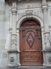 antique wooden brown door against the background of antique columns