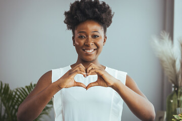 Cropped close up smiling grateful woman showing heart sign, gesture, expressing love and care,...