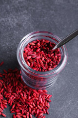 Jar with dried barberries on dark background