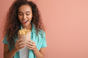 Happy African-American woman with french fries on color background