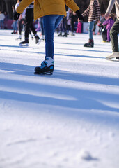 Fototapeta premium Unrecognizable people skating on ice skating rink