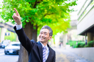 笑顔で指をさすビジネスマン