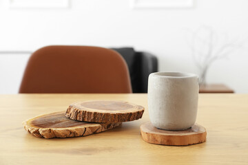 Wooden holders with candle on dining table in room