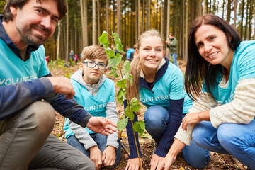 Glückliche Familie mit zwei Kindern pflanzt einen Klimabaum