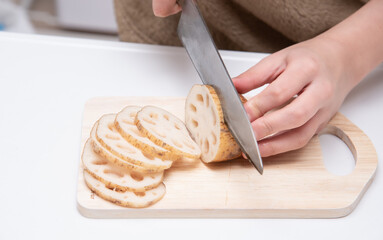 レンコンを切る女性の手元