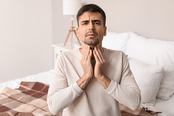 Ill young man with sore throat at home