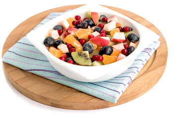 Fruit fresh chopped salad with apple, tangerine, kiwi, cranberries, grapes, blueberries in a white bowl for a healthy diet.