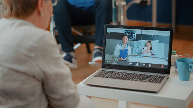 Retired adult using videoconference on laptop to attend online meeting. Elder woman talking to specialist and child on online teleconference call. Remote telecommunication on computer